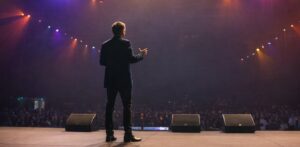 Brett Wiskar on stage delivering adaptability keynote to large conference