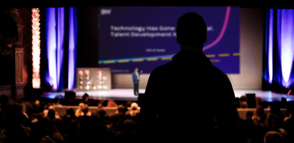 Brett Wiskar Delivering a Keynote presentation with a slide outlining exponential technology vs talent development